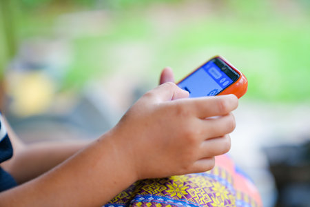 Young girls playing mobile phones on the road or the house cause an accident Or using mobile phones for a long time may cause damage to the eyes Hazardous concepts for children's mobile phonesの写真素材