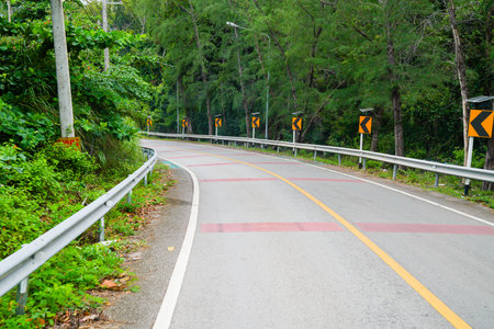 Small curve road through the tropical forest in sunlightの写真素材