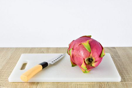 Close up the dragon fruit that is bitten on wood background. Dragon fruit is popular as a fresh...