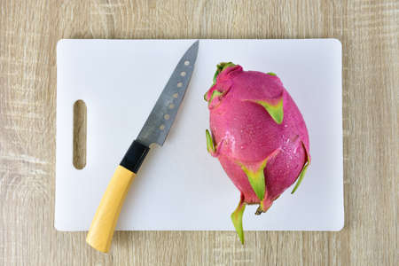 Close up the dragon fruit that is bitten on wood background. Dragon fruit is popular as a fresh fruit.Is a mixture of fruit salad or blended into juice.の写真素材