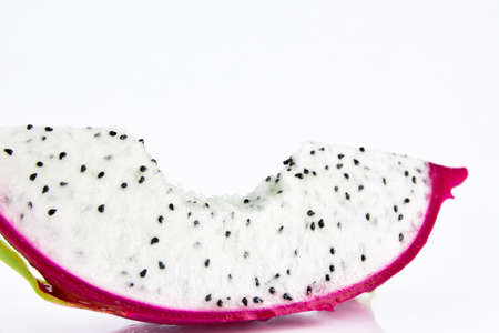 Close up the dragon fruit that is bitten on white background. Dragon fruit is popular as a fresh fruit.Is a mixture of fruit salad or blended into juice.の写真素材
