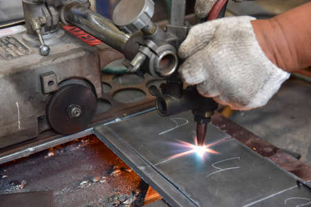Worker cutting metal plate by Gas Cutting Machine in the workshop.の写真素材