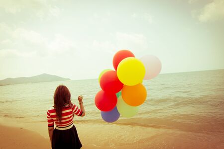 Woman with colorful Balloons on the beach,Outdoors lifestyle filters imagesの写真素材