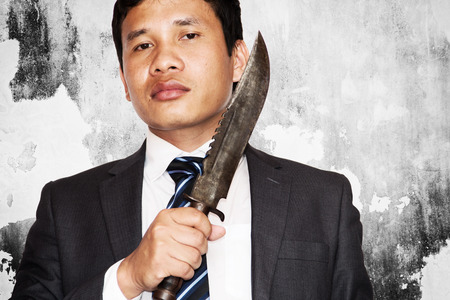 Business competition,Businessman bring out knife ready to fight or protect business.の写真素材