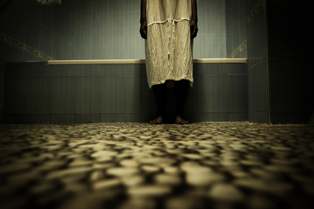 Scary person in white dress standing close to bathtub,Scary background for book coverの写真素材