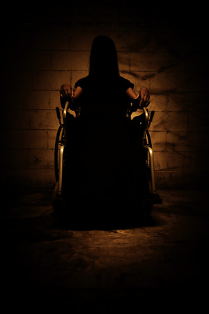 Ghost woman sitting on wheelchair in asylum,Scary background for book coverの写真素材