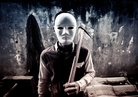 A stranger wearing white mask holding hatchet,Scary background for book coverの写真素材