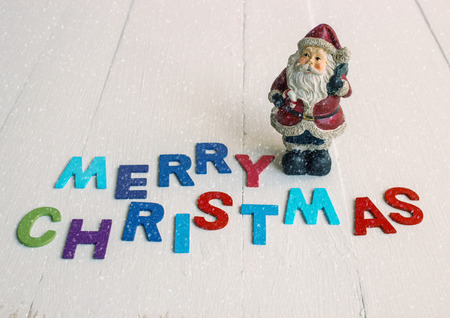 Christmas ornament with Santa claus on wooden background with Merry christmas text and snowの写真素材
