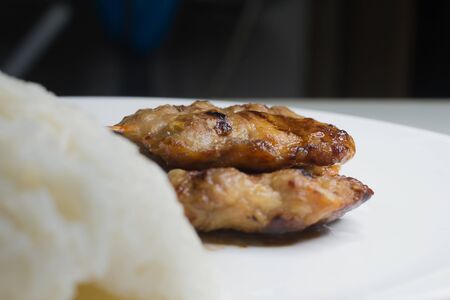 Street food, Thai grilled pork and sticky rice in a white plateの写真素材