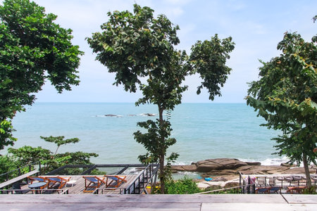 Relaxing spot and viewpoint on the beach With large stones With green trees On a day with turquoise waters and clear skies and beautiful clouds. the picture is partially clear.の写真素材