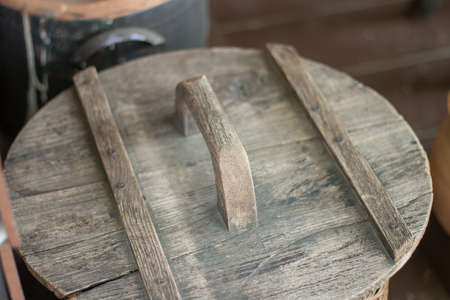 The Thai clay pot lid is made of wood and has a handle for opening.の写真素材