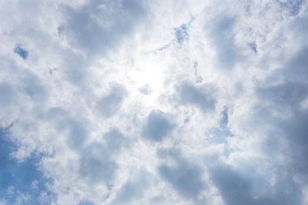 White heap clouds and bright sun in the blue sky.