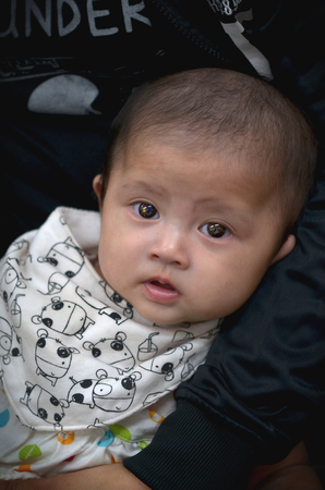 CHAINAT THAILAND, 21 APRIL 2017:Asian babies He was looking around while he was in his mother's embrace. While waiting for physical examination in a baby hospital in Thailand.のeditorial素材