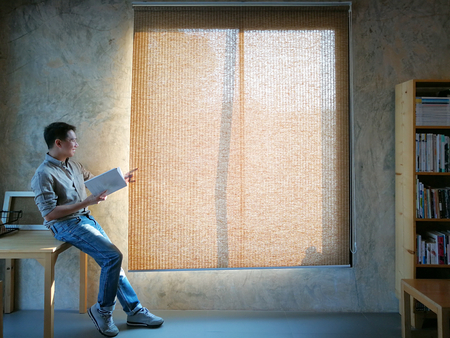 Man reading book near windows ,の写真素材