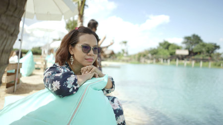 Thailand women sit relaxing on sand beach.travel fashion idea concept