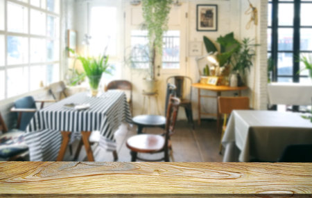 Mockup  empty top wood table .the background of blur indoor cafe in morning time