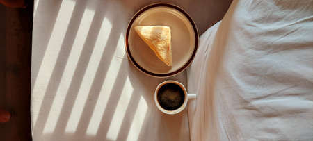 Black coffee and sandwich on white sofa in morning time. It space background of put document presentの写真素材