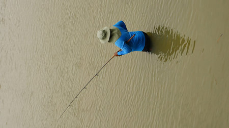 fisherman fishing on the river in the rain, view from above