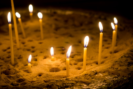 Candle glowing in dark roomの写真素材