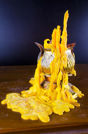 Beautiful candle dripping on wooden tableの写真素材