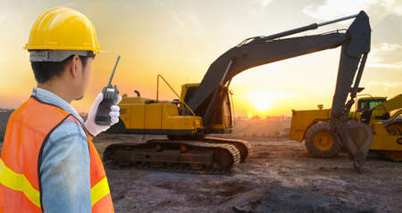 Confident supervisor using walkie-talkie at construction siteの写真素材