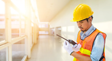 Confident supervisor using walkie-talkie at construction site