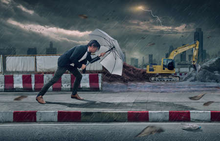 Businessman with White umbrella protecting himself from the storm.  Business heavy tasks and problems concept.の写真素材