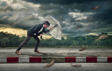 Businessman with white umbrella protecting himself from the storm.  Business heavy tasks and...