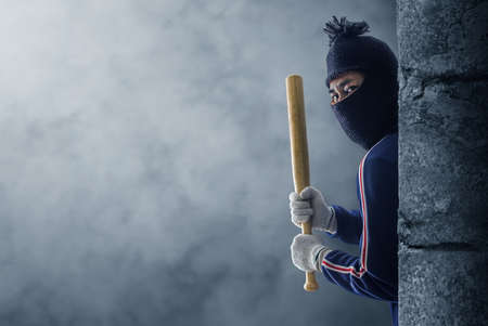Criminal or bandit holding a baseball bat.の写真素材