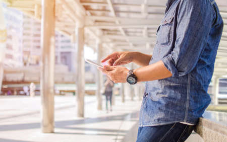 man is playing on his mobile phone in the outdoorの写真素材