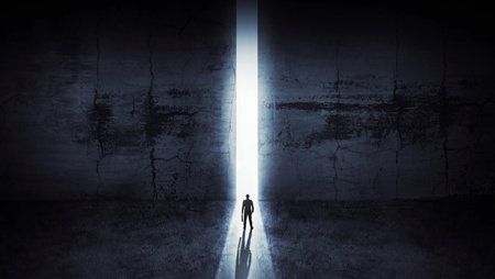 Businessman looking out of abstract opening in wall with bright daylight in concrete interior. Concept for successの写真素材