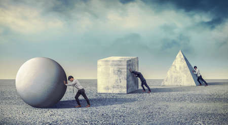 Businessman pushing the round large stone. Business heavy tasks and problems concept. differentiation between workの写真素材