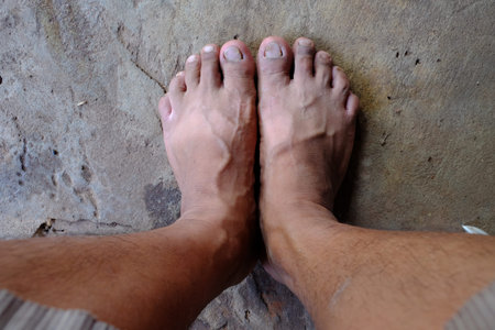 Dirty feet on the cement floor.