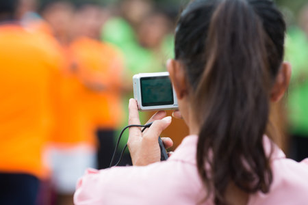 Woman taking a photograph of people with digital camera