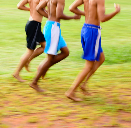 Tree people no shirt running on the field の写真素材
