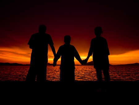 Silhouette of family at sunriseの写真素材