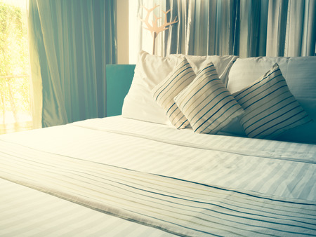 vintage bed sheets and pillow messed up in the morningの写真素材