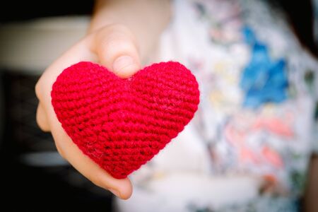 Female hands giving red heart, valentines day conceptの写真素材