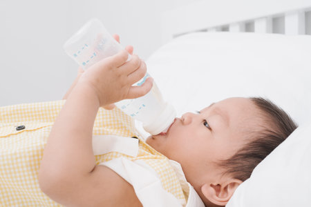 Asian baby boy drinking milk from bottle.の写真素材