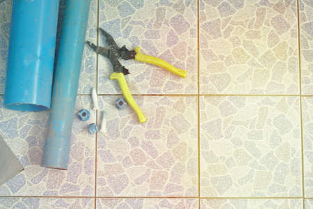 Pvc hose pliers on the bathroom floor tiles.の写真素材
