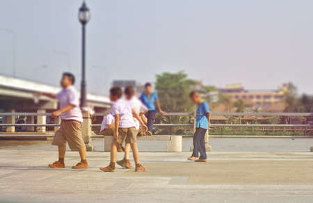 A group of children in a white school uniform and a blue sky running along the river.The school students play cheerfully along the river after schoolのeditorial素材