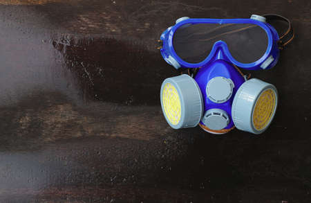 Anti-smoke mask to protect the blue eyes from the damp wood background.Conservation-Professional restoration Use a gas mask that is isolated on the old wooden floorのeditorial素材
