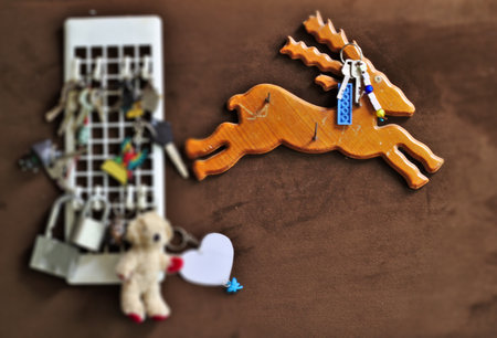 Key chain hanger, multi-key padlock on brown background, blurry picture, deer-shaped wooden panelのeditorial素材