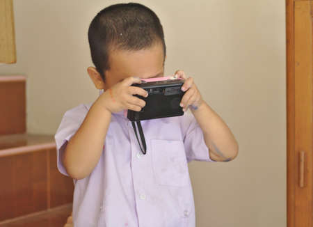Kindergarten children in the school uniform hold a camera to take a black photography.のeditorial素材