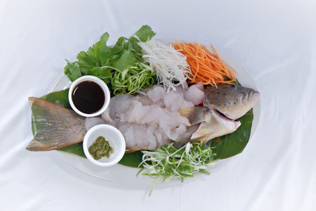 Sashimi is a Japanese delicacy consisting of fresh raw fish sliced into thin pieces decorated with vegetables like sliced celery, spring onion, carrot and often eaten with soy sauce and wasabi.の写真素材