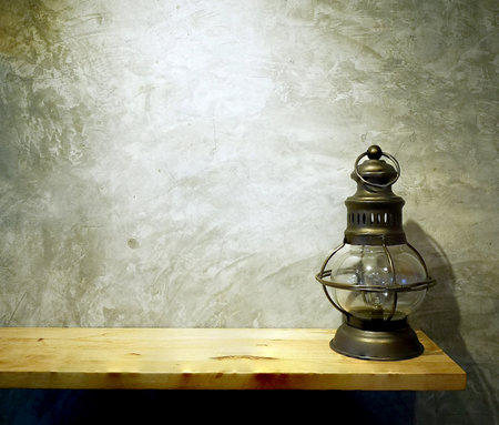 Copy space view still life with vintage lamp on wooden table over grunge background. Copy space for your text.の写真素材