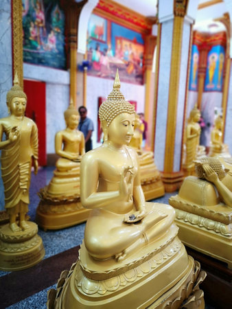 Sideview of golden Buddha statue illuminated sculpture of Thailand in the temple. Phuket, Thailand.の写真素材