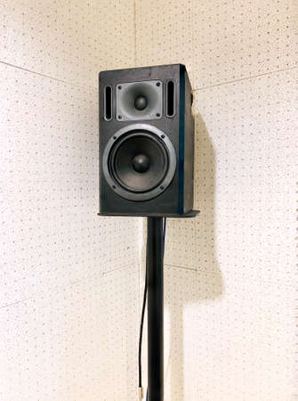 A studio monitor, high quality speaker on the metal stand with acoustic board, sound absorption wall as the white background.の写真素材