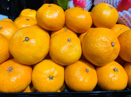 Fresh unpeeled orange tangerines mandarins, Clementines, as citrus fruit background in the supermarket, Chonburi, Thailand.の写真素材