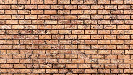 Front-view photography of red-brown not plastered weathered solid brick wall with traces of dirt, grunge, uneven color, rugged surface peeling. Abstract copy space seamless background texture.の写真素材